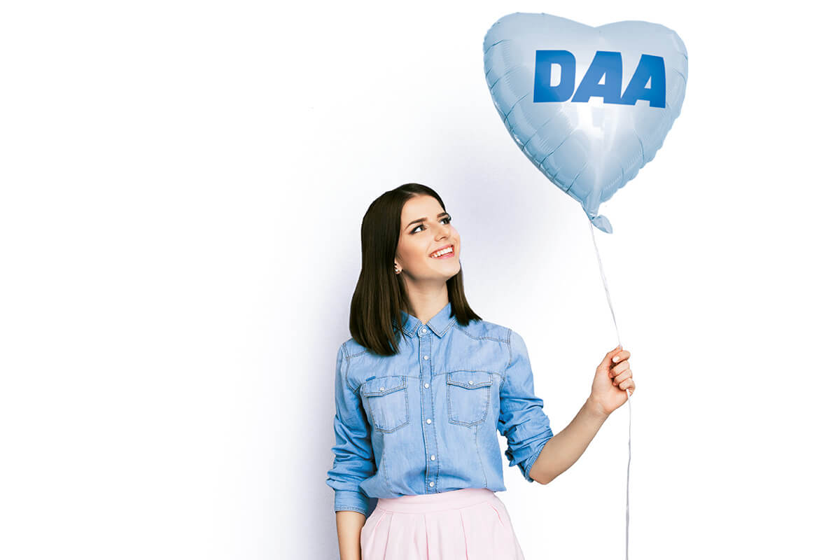 Frau mit DAA-Luftballon in Herzform
